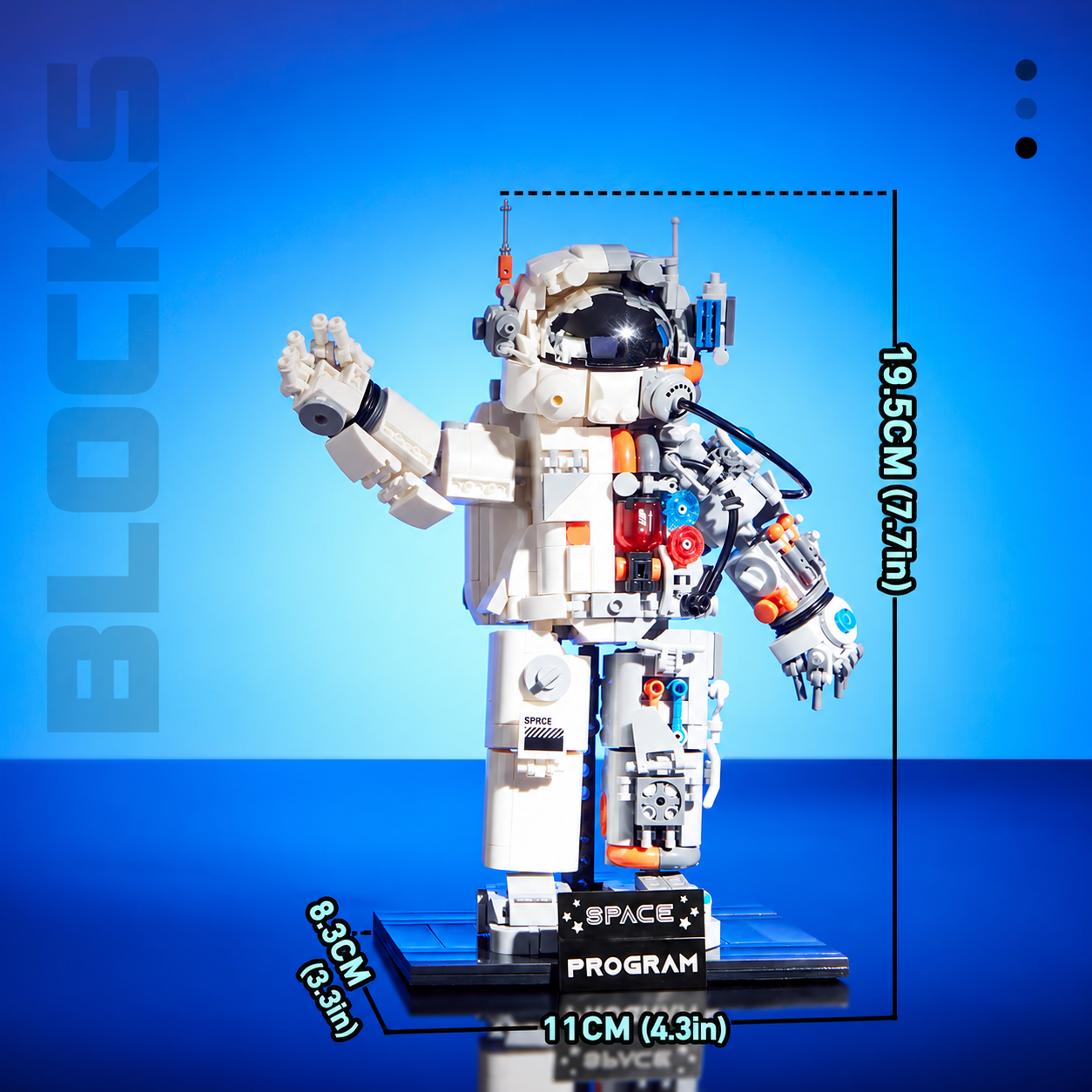 Mechanical astronaut on its base with dimensions marked as 11 cm (4.3 in), 8.3 cm (3.3 in) and 19.5 cm (7.7 in).